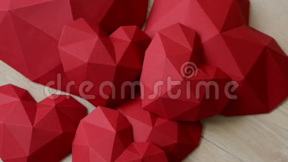三个红色的多角形纸心形在木桌上视频的预览图