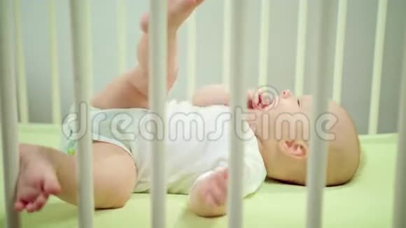 婴儿躺在婴儿床上吃它的手指视频的预览图
