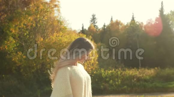 微笑的年轻女子在秋天享受大自然视频的预览图