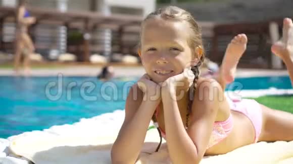 漂亮的小女孩在室外游泳池附近玩视频的预览图