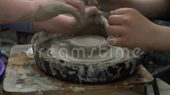 教师和学生在一个车间的陶轮上做一个陶瓷碗视频的预览图