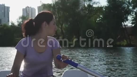 美丽的女孩在湖上划船视频的预览图