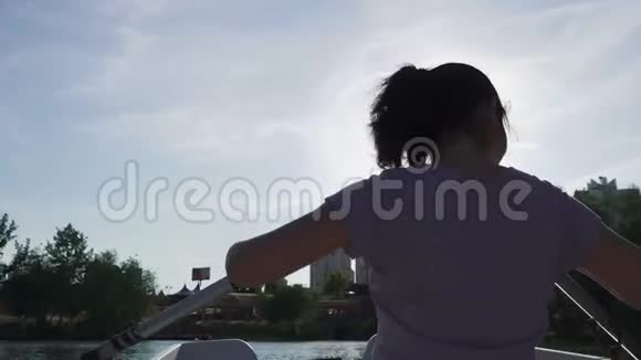 美丽的女孩在湖上划船视频的预览图