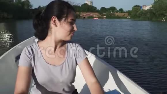 美丽的少女在湖上划船视频的预览图