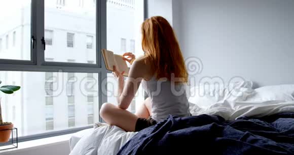 女人在家里的卧室里看书视频的预览图