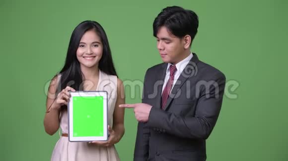 年轻的亚洲商务夫妇在绿色的背景下在一起视频的预览图