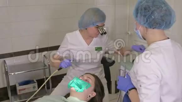 牙医诊所的妇女得到牙科治疗以填补牙齿的空洞牙科修复和复合材料视频的预览图