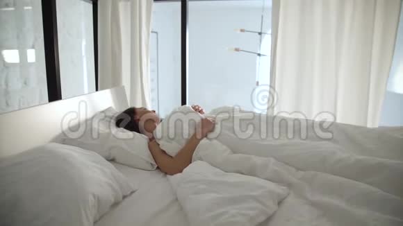 睡觉女人睡在床上在轻卧室有白色被褥视频的预览图