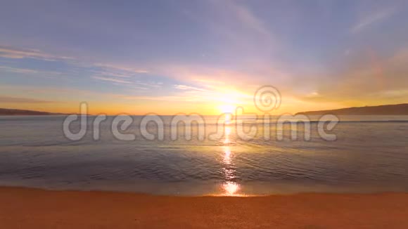 海滩上的热带日出波浪洗沙子视频的预览图