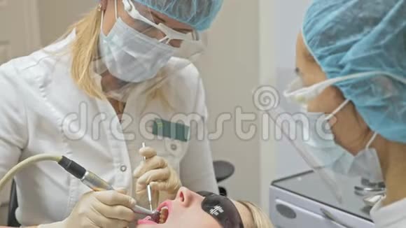 牙医在现代牙科诊所治疗病人正畸医生与一名助手合作在运作中围堰是视频的预览图