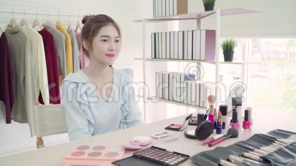 美女博主展示了坐在镜头前录制视频的美容化妆品漂亮的亚洲女人用化妆品视频的预览图