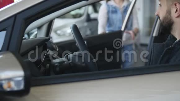 幸福的年轻一家坐在一辆新车上的经销商视频的预览图