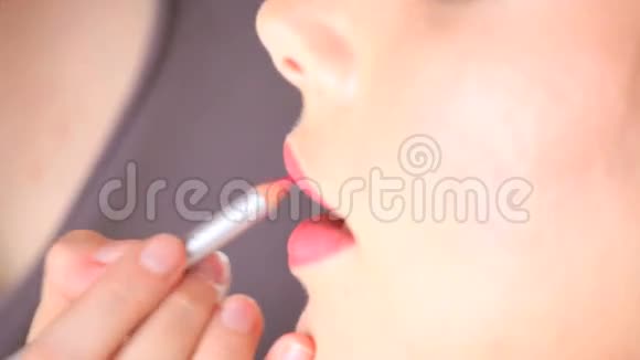 化妆师用铅笔在模特嘴唇上涂口红视频的预览图