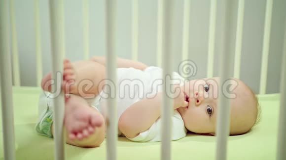 婴儿躺在婴儿床上吃它的手指视频的预览图