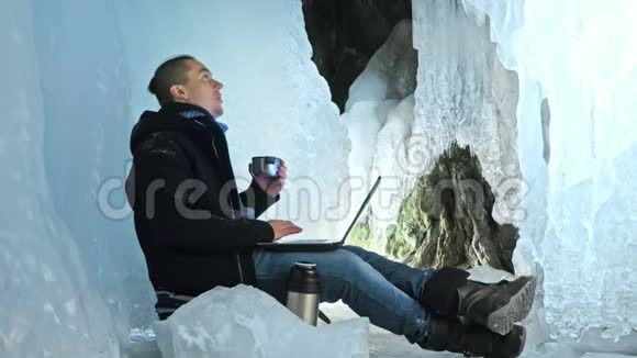 人们坐在冰洞里的笔记本电脑上围绕着神秘美丽的冰窟用户在视频的预览图