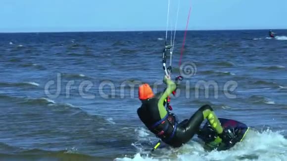 慢动作一个雄风筝冲浪者在水面的木板上滚动视频的预览图