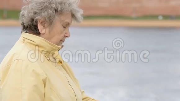 老妇人看着腕带健身追踪器视频的预览图