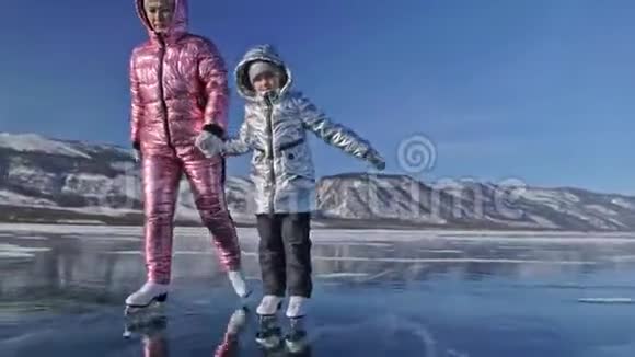 家人白天在滑冰女孩们骑着大自然中的花样冰鞋妈妈和女儿一起骑在冰上视频的预览图