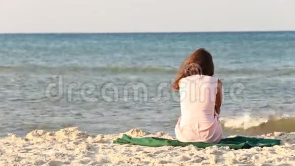 坐在海滩上的女孩视频的预览图