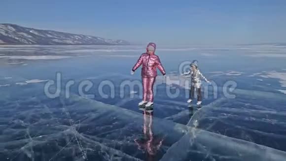 家人白天在滑冰女孩们骑着大自然中的花样冰鞋妈妈和女儿一起骑在冰上视频的预览图