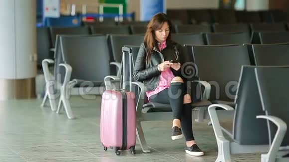 航空公司乘客在机场休息室等待航班飞机带智能手机的白人女人在候诊室视频的预览图