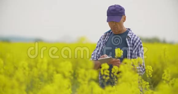 用数字平板电脑查看田间花开的农民视频的预览图