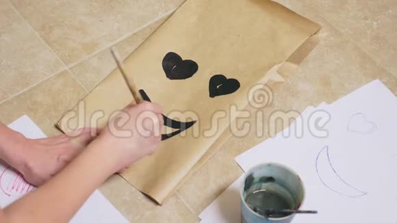 女孩用画笔在纸袋上画出各种情感微笑中的情感概念视频的预览图