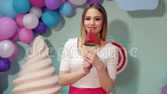 快乐的女孩带着糖果在明亮的背景上视频的预览图