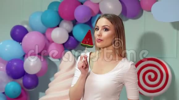 快乐的女孩带着糖果在明亮的背景上视频的预览图