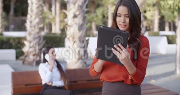 年轻的女商人在户外使用平板电脑视频的预览图
