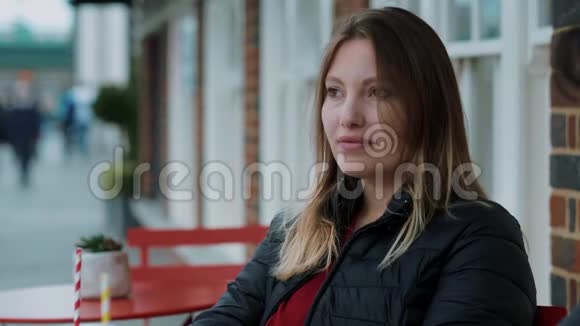 一家街头咖啡馆的年轻女子视频的预览图