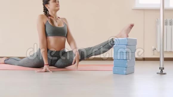 健身女性在运动垫上做伸展运动室内健身垫运动的年轻女子视频的预览图