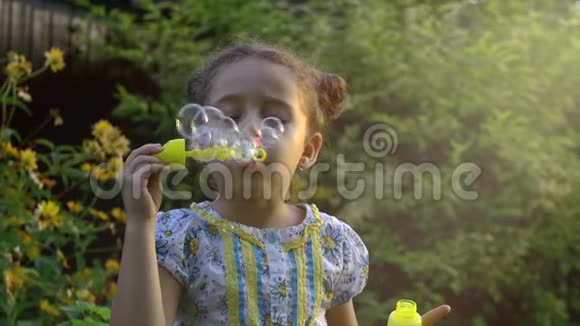 快乐的孩子在公园里吹肥皂泡慢动作库存录像视频的预览图