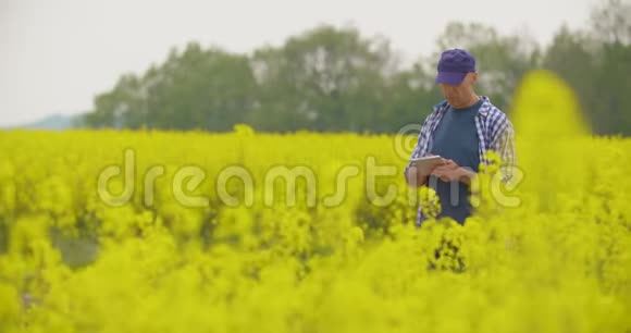 用数字平板电脑查看田间花开的农民视频的预览图