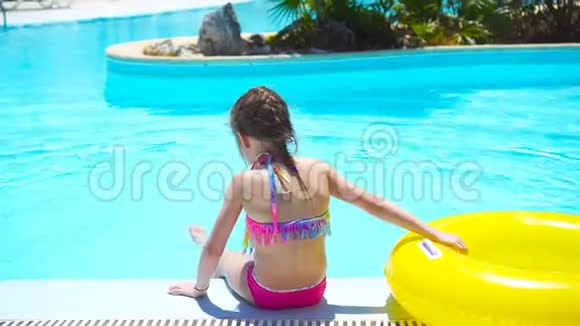 游泳池里有充气橡皮圈的小女孩视频的预览图