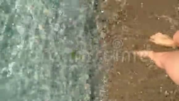 女人的腿站在金色的沙滩上溅起海水个人看法视频的预览图
