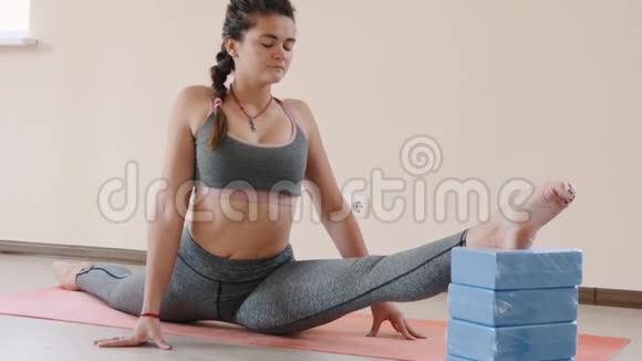 健身女性在运动垫上做伸展运动室内健身垫运动的年轻女子视频的预览图