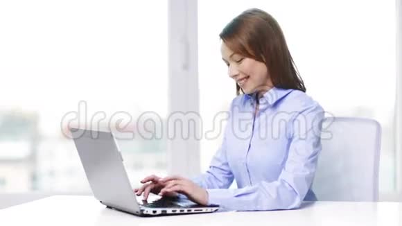 办公室里拿着笔记本电脑微笑的女商人视频的预览图