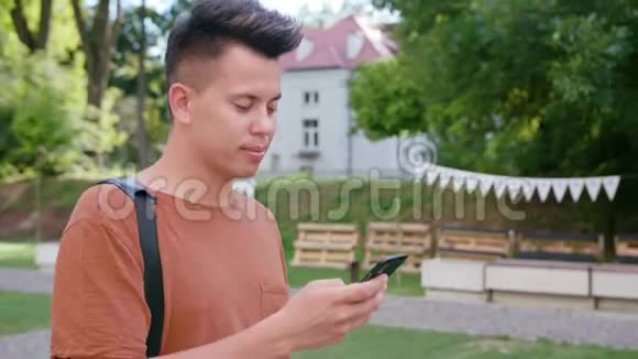 在城里散步和使用电话的年轻人视频的预览图