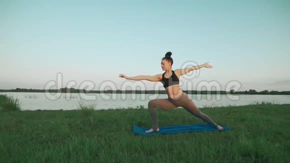 年轻女子早上在蓝色瑜伽垫上做瑜伽安静的风景视频的预览图