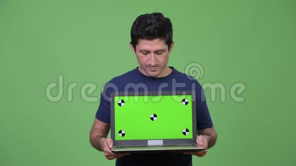 快乐的西班牙男人展示笔记本电脑视频的预览图
