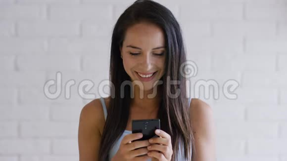 微笑的黑发使用智能手机视频的预览图