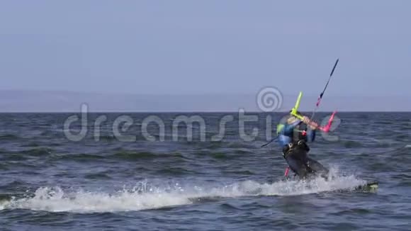 慢动作一个雄性的风筝冲浪者在水面上滚动视频的预览图
