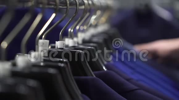 购物和时尚概念年轻人在商场或服装店挑选和试穿夹克视频的预览图