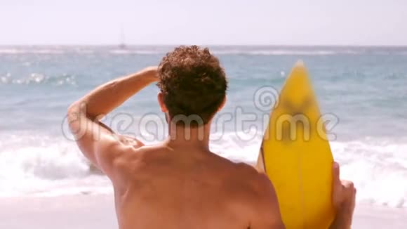 一个人拿着冲浪板看着大海视频的预览图