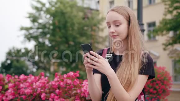 年轻的红头发女士在城里用电话视频的预览图