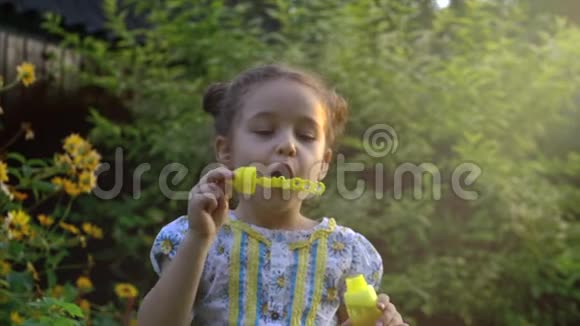 快乐的孩子在公园里吹肥皂泡慢动作库存录像视频的预览图