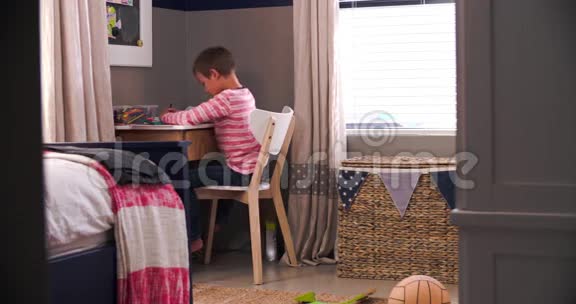 男孩坐在书桌前在卧室做作业视频的预览图