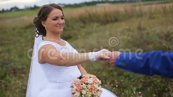快乐美丽的新娘新郎走在田野上视频的预览图
