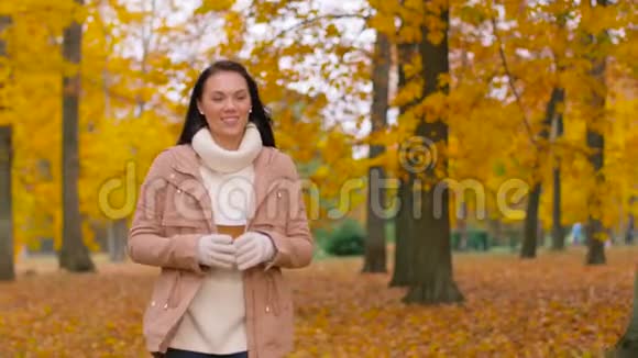 在秋天公园喝外卖咖啡的女人视频的预览图